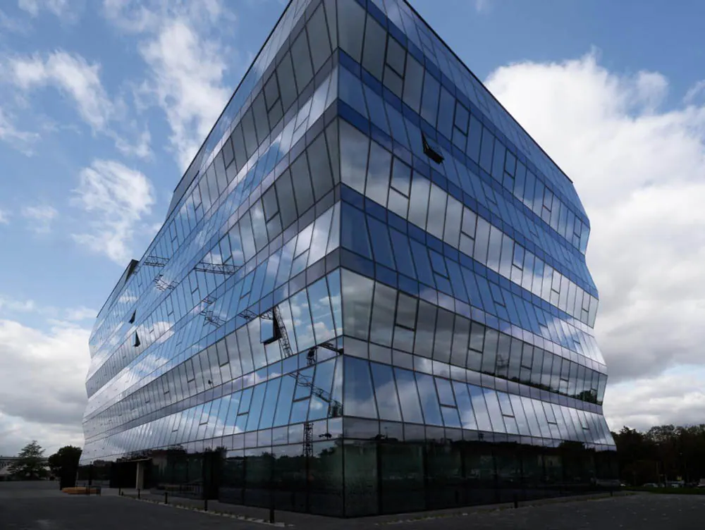 A modern glazed commercial building under a bright sky