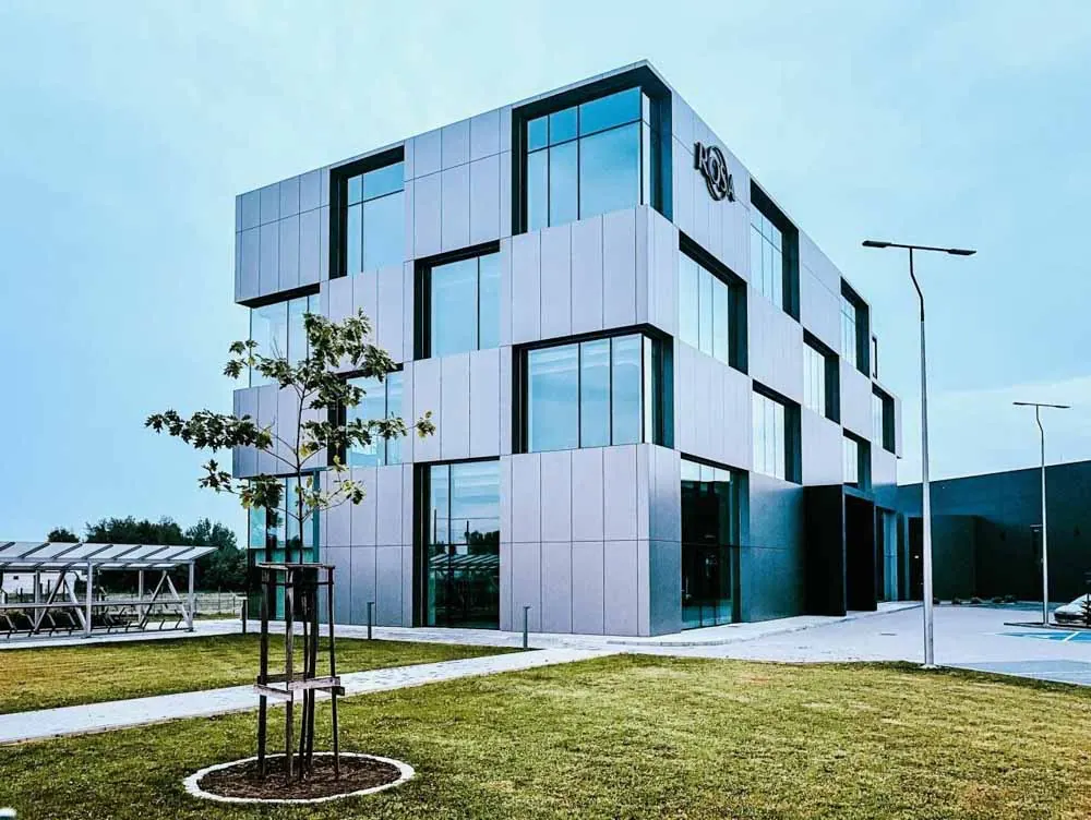 A faceted glazed facade under a clear sky