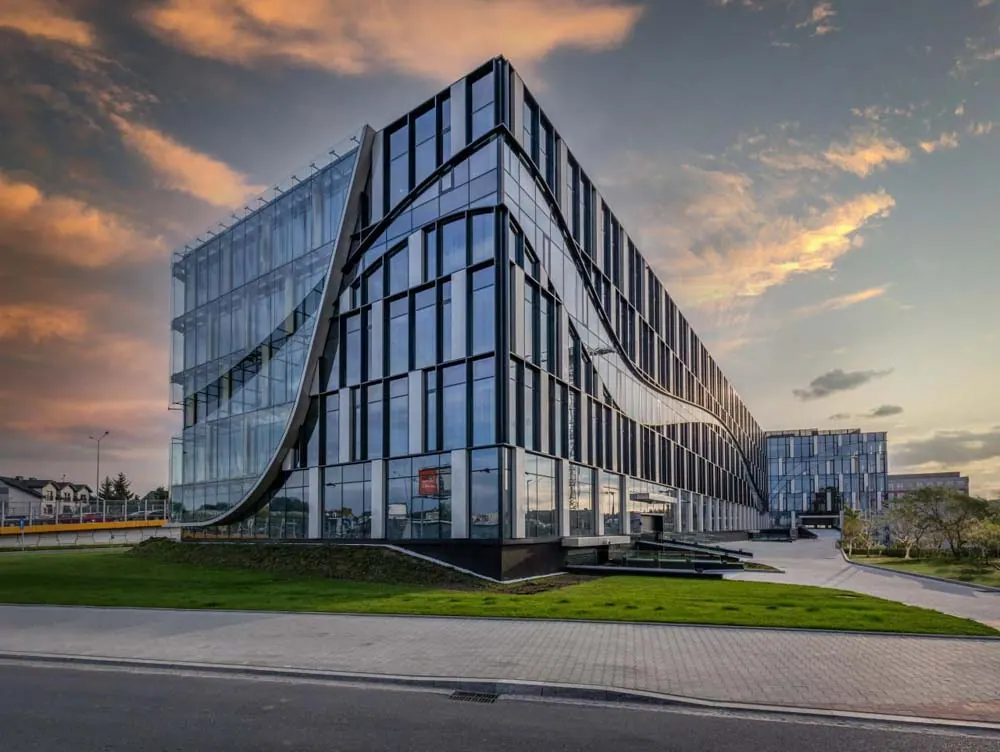 A curved glazed facade catching low evening light
