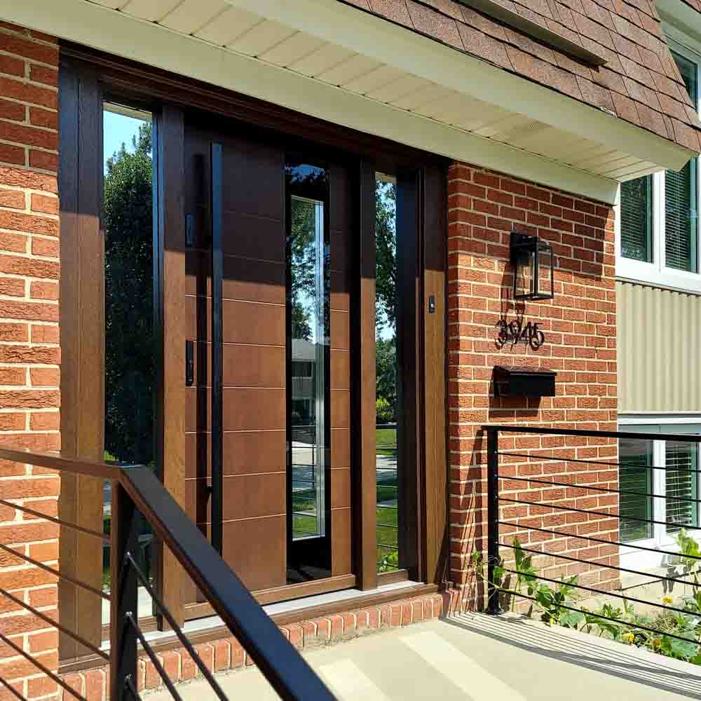 Main door of a house made of wood with two sidelights having reflective glass, a metal bar handle and two locksets