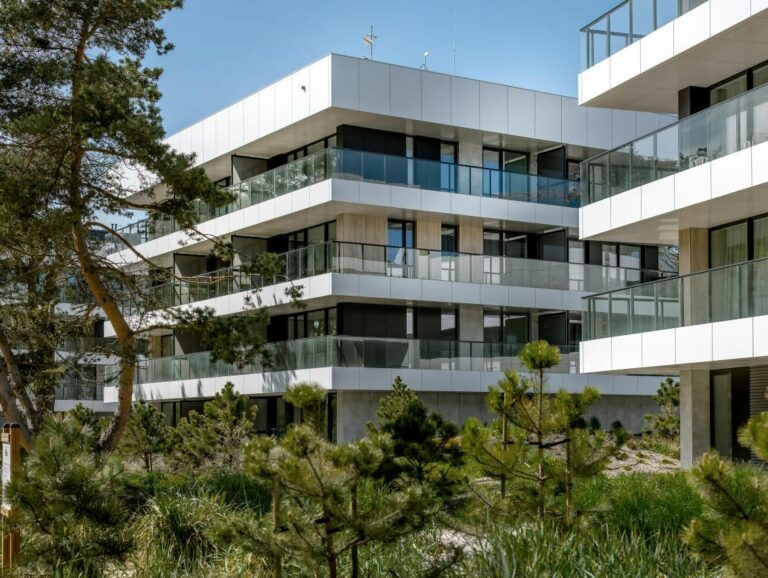 A Hotel with Veranda, protected by metal railings with glass framing walls, glass windows are from ceiling to floor.
